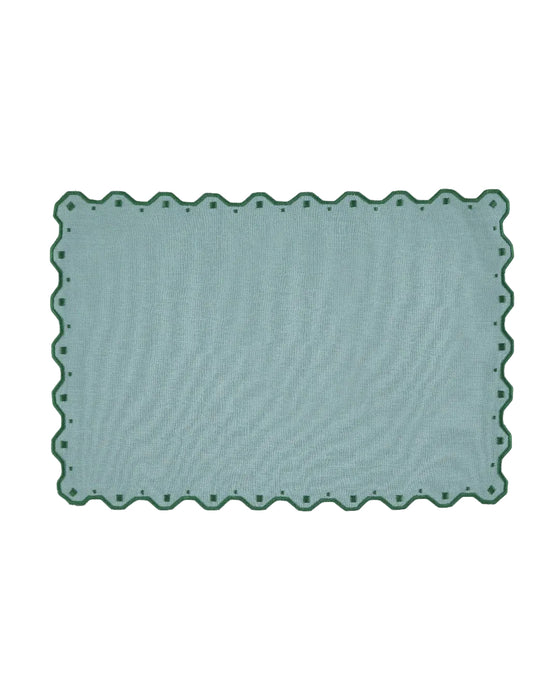 Rectangular green rug with scalloped edge on a white background