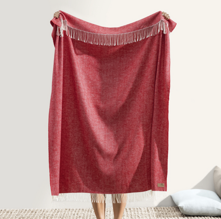 Red throw blanket with fringe on a white background