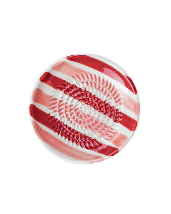 Decorative plate with red and white pattern on a pink background