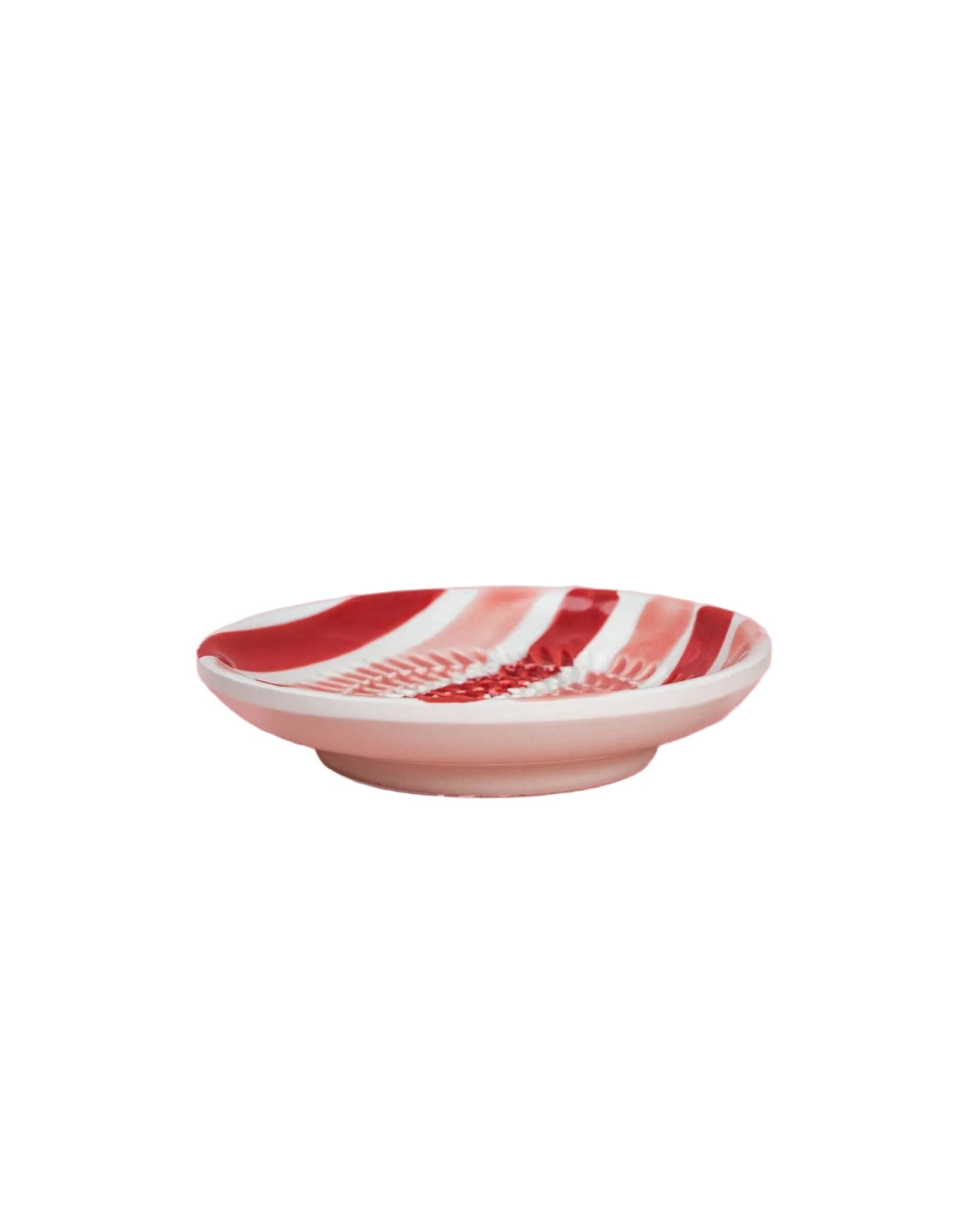 Decorative plate with red and white pattern on a pink background
