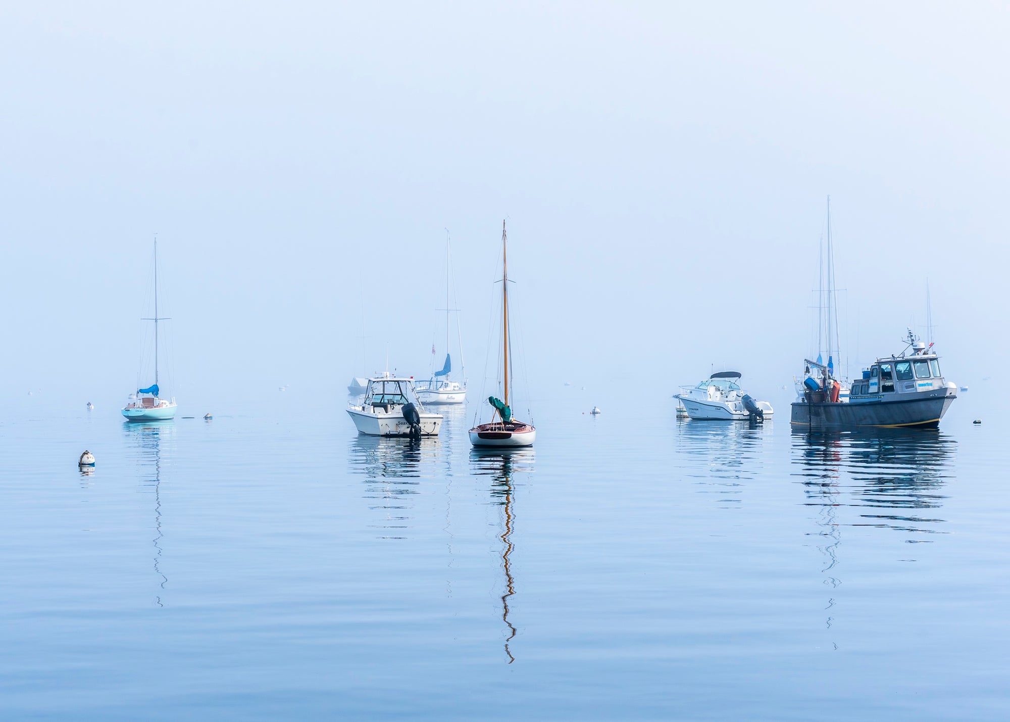 Boats anchored in calm water with a clear sky