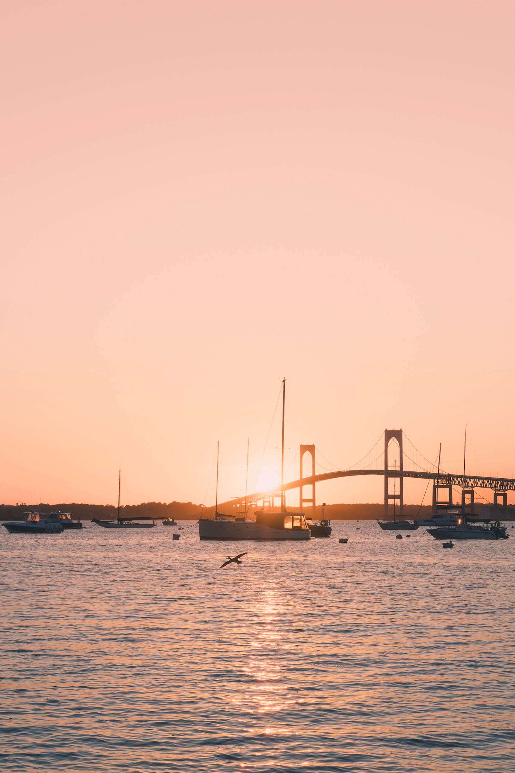Sunset over a bridge with boats on water