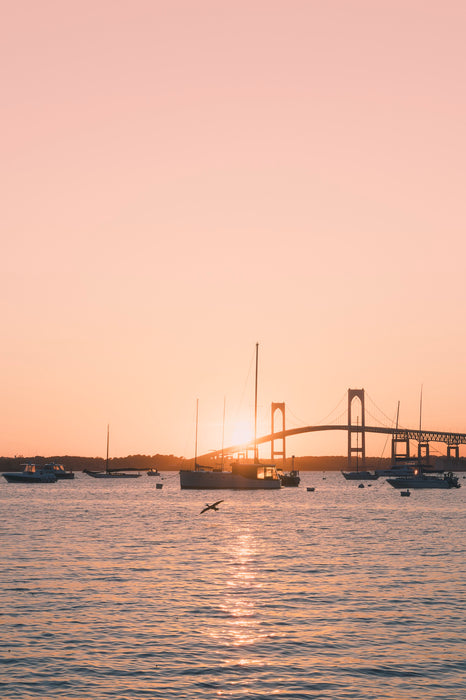 Sunset over a bridge with boats on water