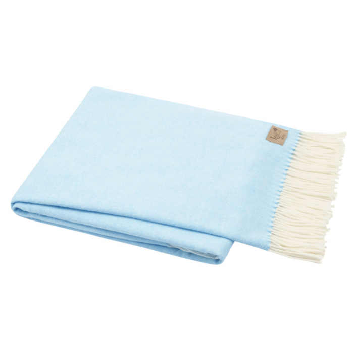 Light blue blanket with white fringe on a white background