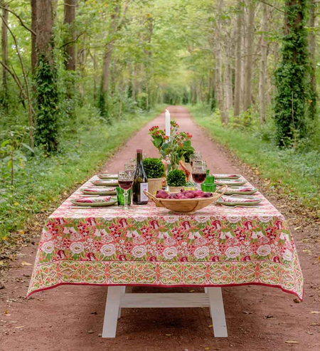 Dining table set with a floral tablecloth in a forest setting