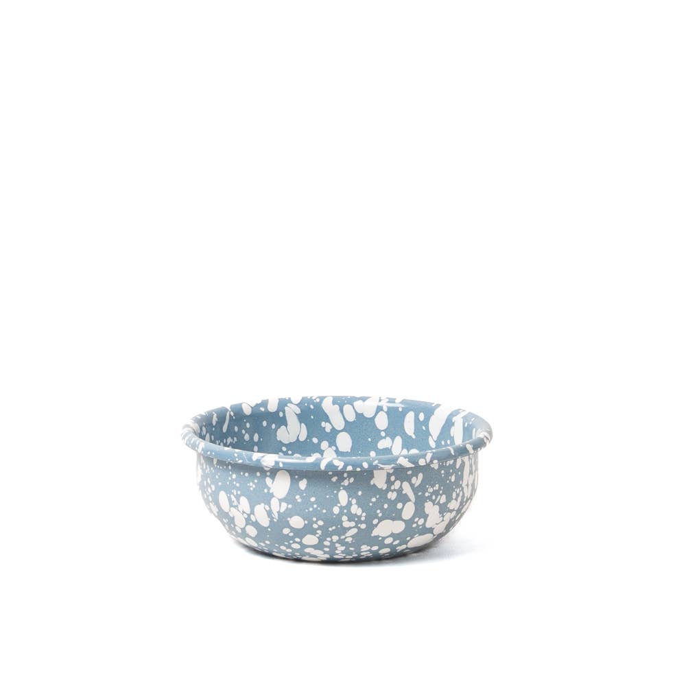 Blue ceramic bowl with white speckled pattern on a white background