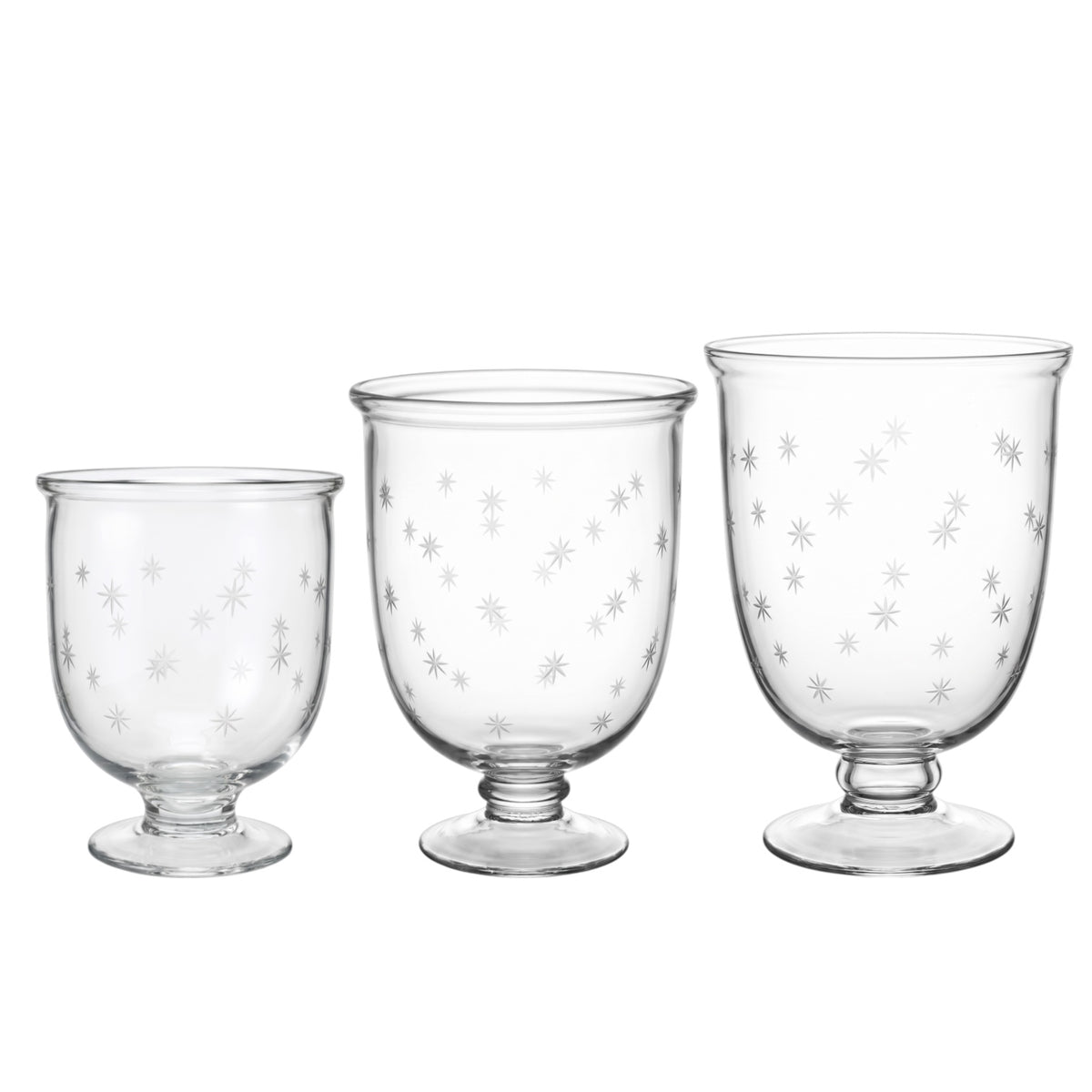 Three clear glass goblets in graduated sizes, each decorated with a delicate pattern of small silver snowflakes, set against a plain white background.