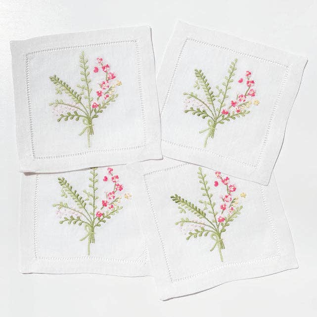 Set of 4 linen embroidered cocktail napkins with pink, green and white floral detail on white background 