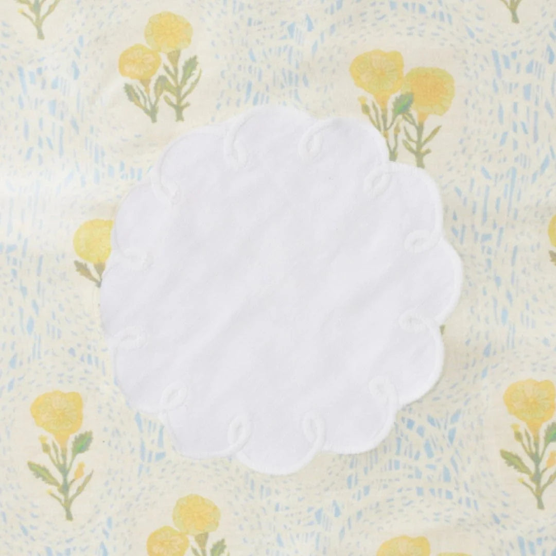 white embroidered cocktail napkin on floral background