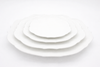 Set of white ceramic plates of different sizes on a white background