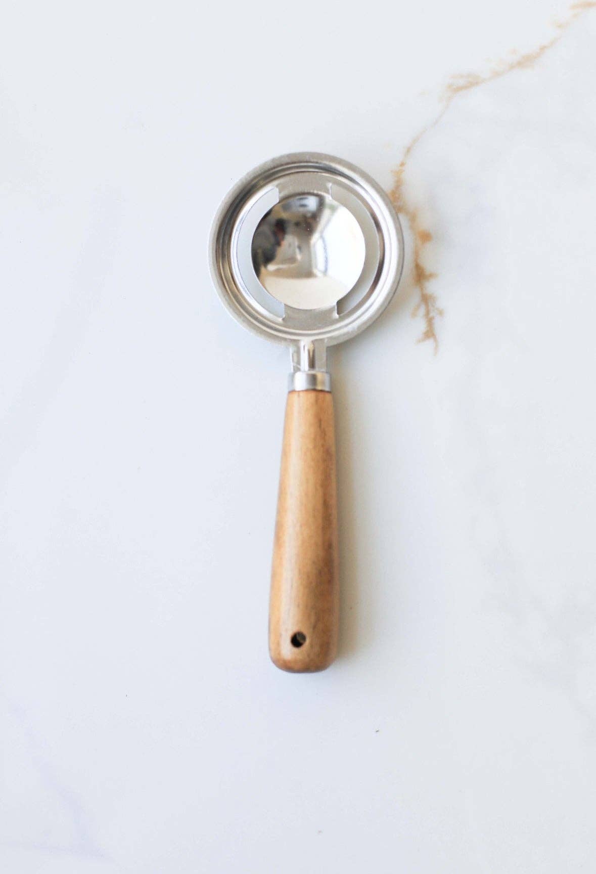 Egg white separator made of stainless steel filter and acacia wood handle with slotted metal spoon design for quick, mess free separation 