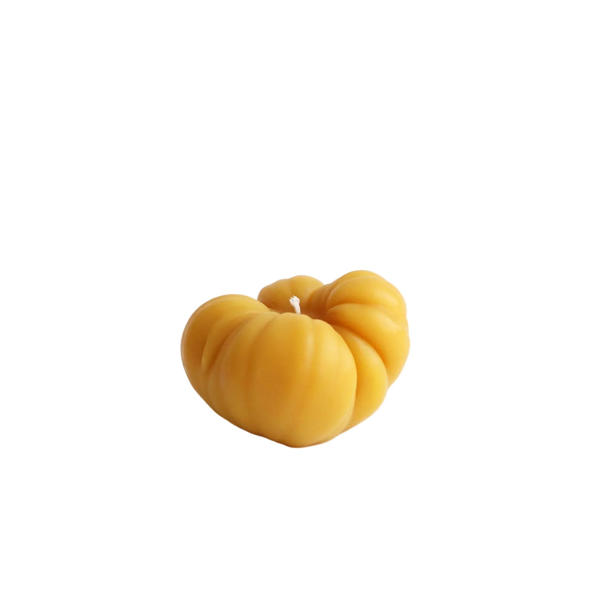 Yellow candle shaped like a pumpkin on a white background