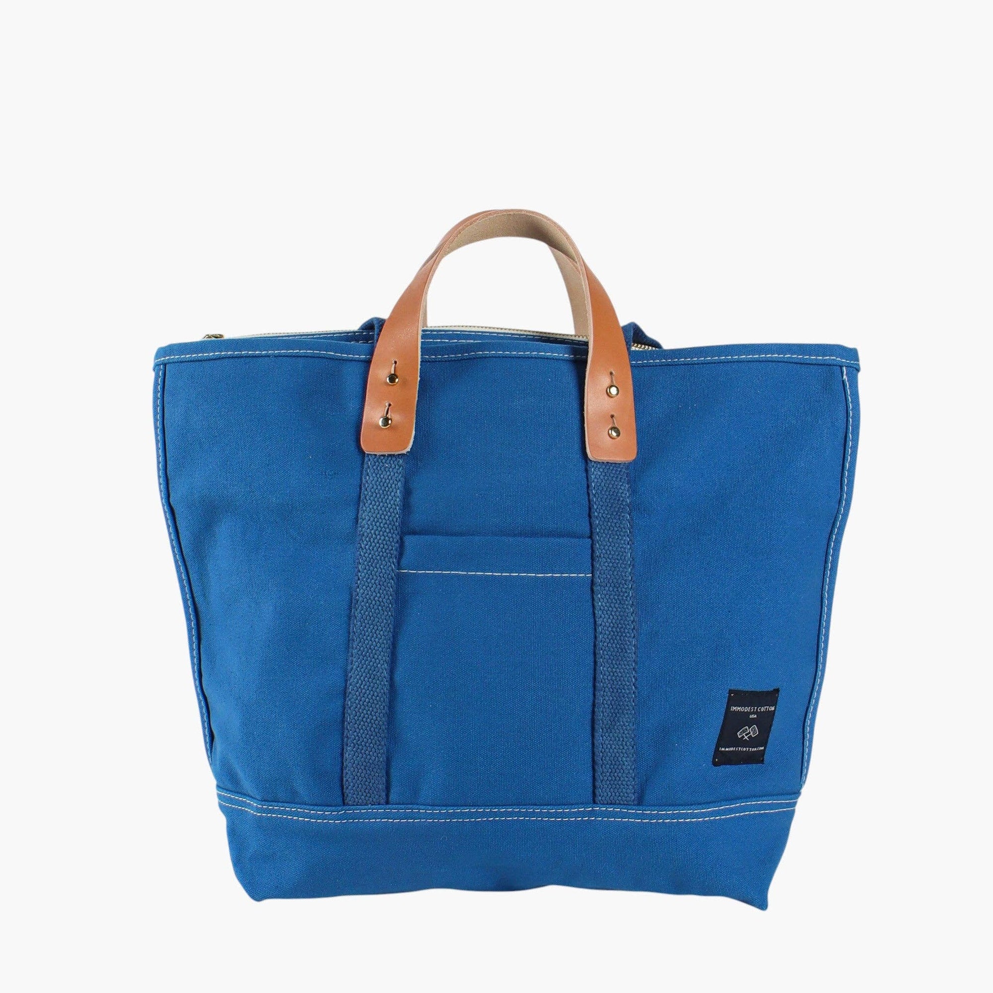Blue zipper tote bag with leather removable handles and canvas shoulder strap on white background 