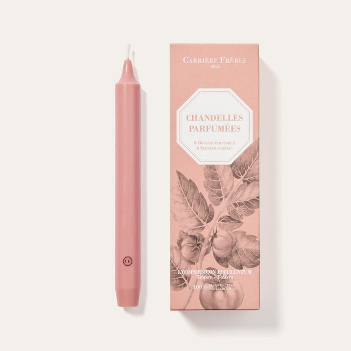 Pink candle and its packaging on a light gray background