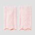 2 coral on ballet pink scalloped hand towels on grey background