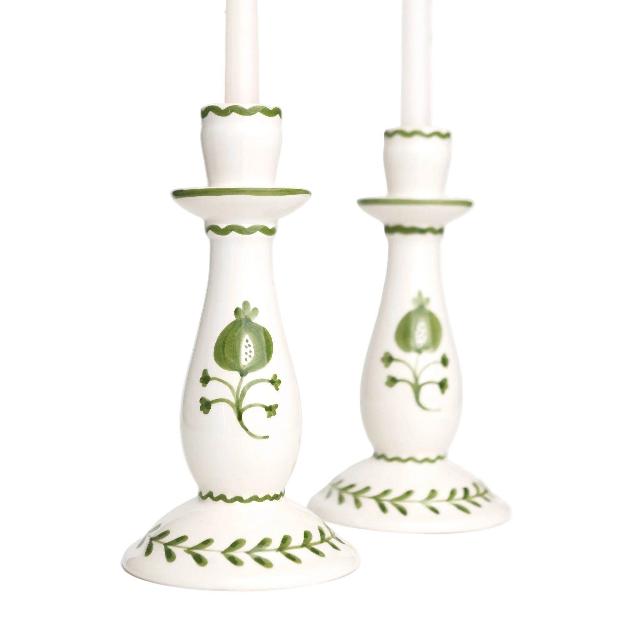 White candle holders with green floral patterns on a white background
