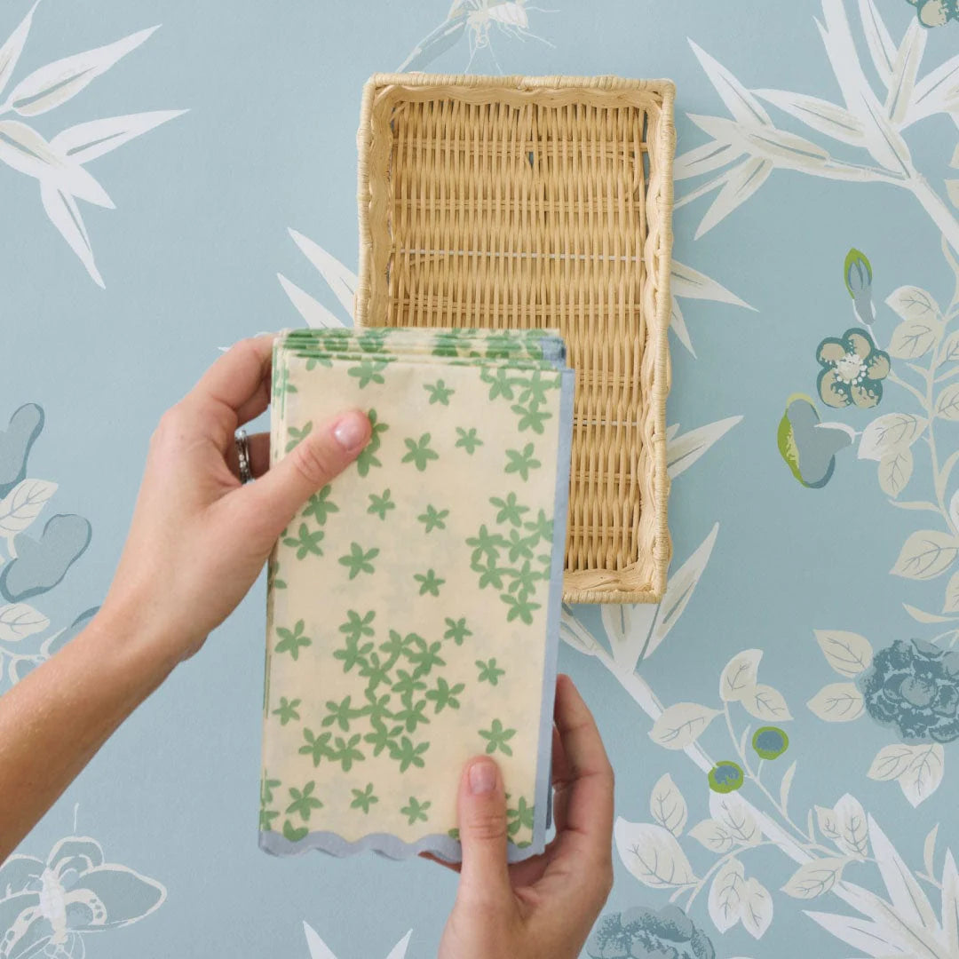 paper napkins with wicker holder on floral background
