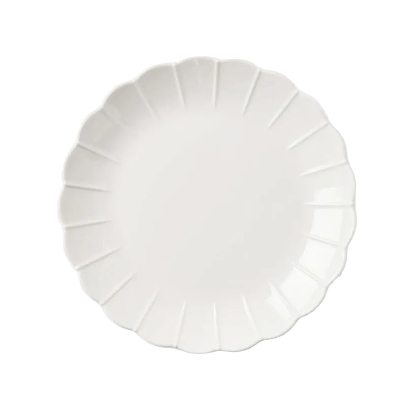 A set of white melamine tableware, including a round dinner plate and a bowl, with scalloped edges.