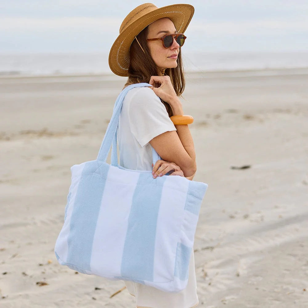 Light blue stripe beach bag on woman with hat on beach