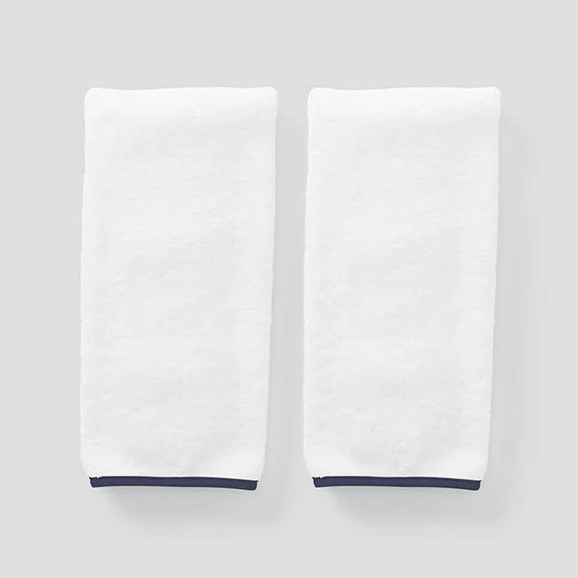 Set of two signature hand towels with navy trim on white background 
