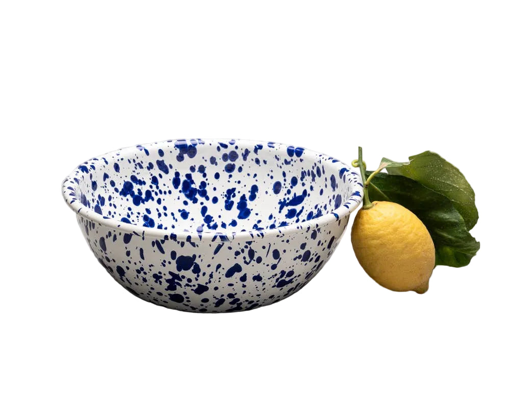 Blue and white speckled ceramic bowl with a lemon on a gray background