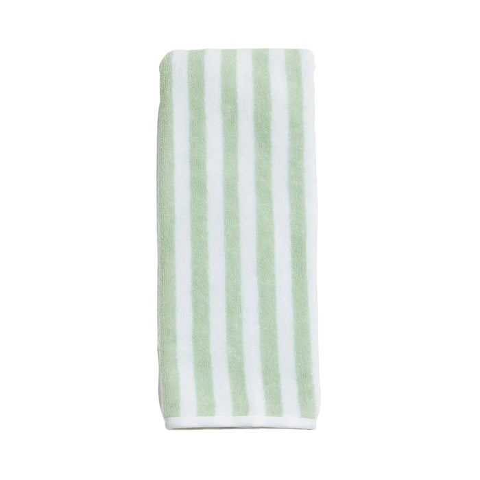 Striped towel with green and white stripes on a light gray background