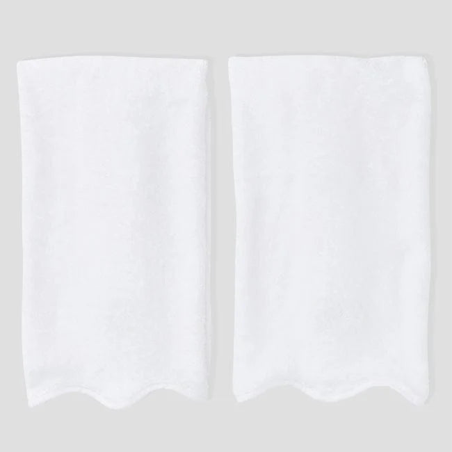 2 white on white scalloped hand towel on grey background